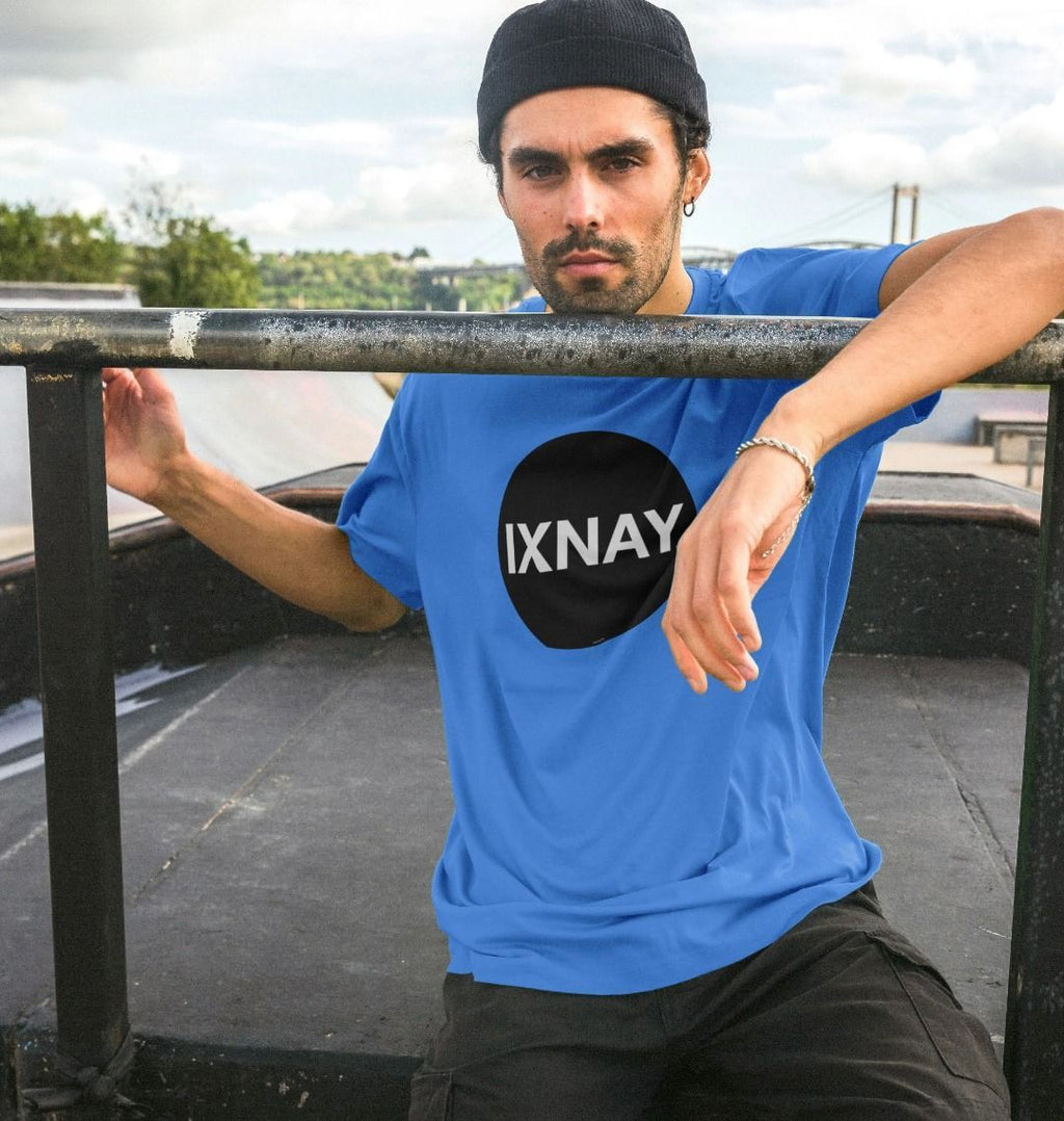 Man at skate park wearing bright blue  Printed Men's T-Shirt with Original Black Round IXNAY Logo to represent the artist and musician IXNAY