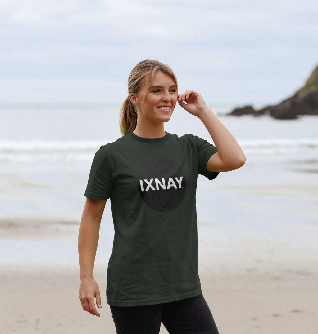 Woman smiling on the beach wearing a dark gray Printed Men's T-Shirt with Original Black Round IXNAY Logo to represent the artist and musician IXNAY