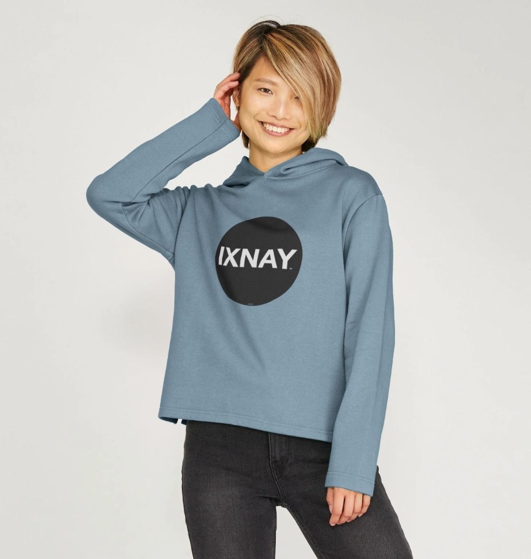 Smiling asian woman in front of gray background wearing womens black organic pullover hoodie with original black round IXNAY logo