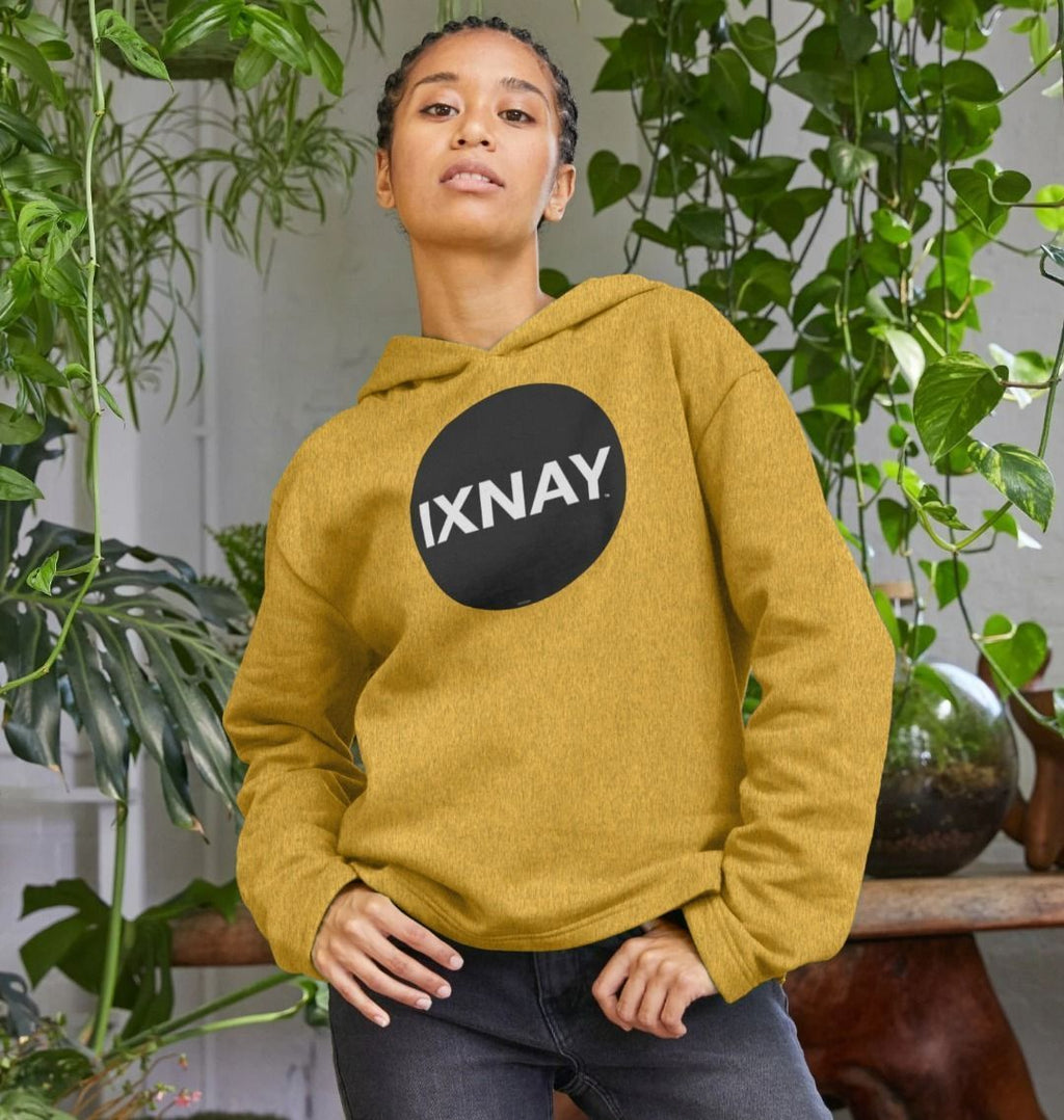 black woman with cornrows in plant-filled room wearing womens sunflower yellow organic remill pullover hoodie with original black round IXNAY logo